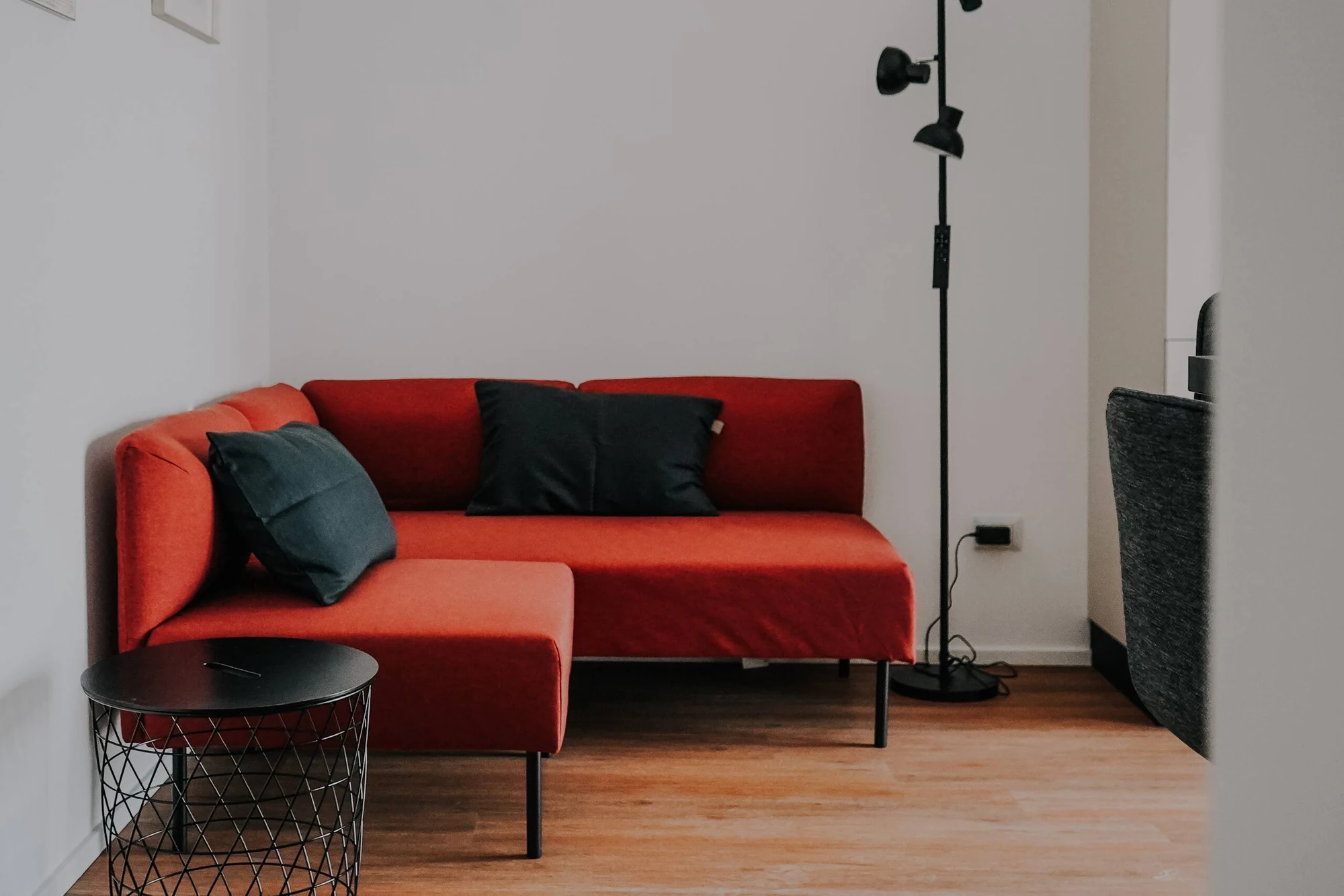 Casa Lollo – Trastevere, Roma: la zona living con il divano rosso e i quadri alla parete