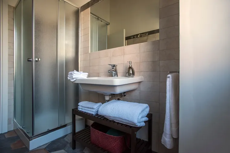 Domus Giulio, Roma: il bagno con la doccia e il lavabo su struttura in metallo
