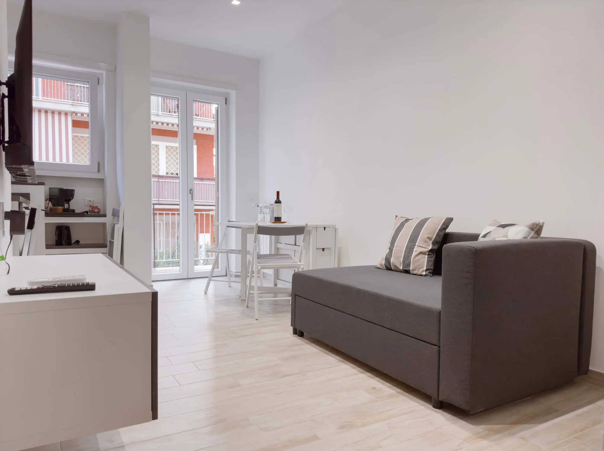 Flora's Apartment, Roma: la zona living con il divano e l'angolo cottura